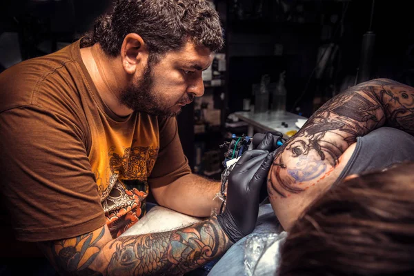 Professional tattooist makes tattoo pictures in studio