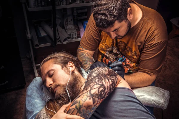 Tatuagem fazendo uma tatuagem no salão de tatuagem — Fotografia de Stock