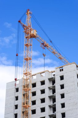 Yapım aşamasında yüksek binalar ve mavi gökyüzü altında Vinçler için içinde yer