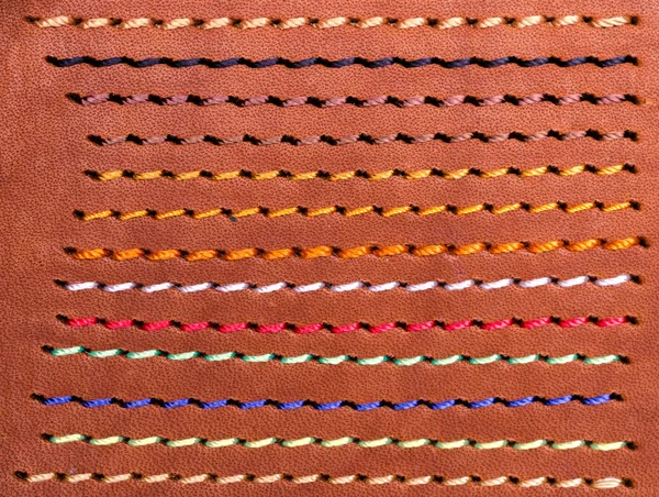Muchas líneas de hilo de color un pedazo de piel amarilla — Foto de Stock