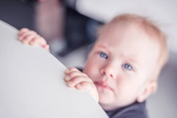 A little cute girl barely reaches the table Stock Photo