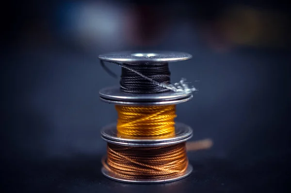 Three colored thread bobbins stacked on top of each other — Stock Photo, Image