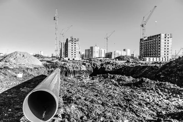 Крупный план пластиковой трубы на черной земле на строительной площадке — стоковое фото
