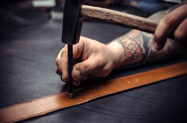 Sihirbazı deri erkek kemer delik yumruk atıyor.