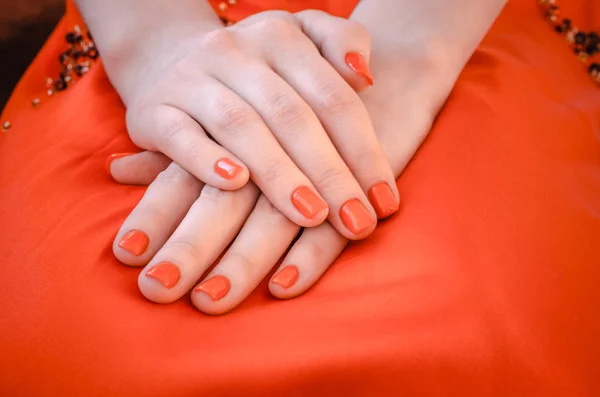 Mãos de mulher com esmaltes vermelhos — Fotografia de Stock