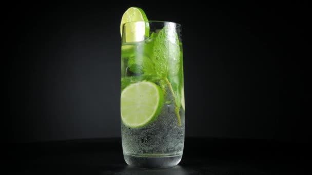 Mojito cocktail with lime, mint and crushed ice in cold wet glass — Stock Video