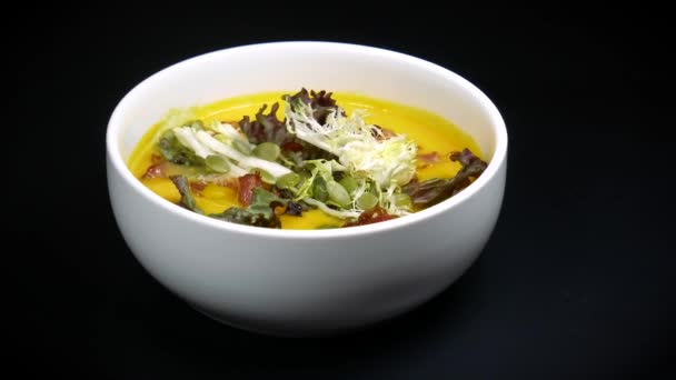 Heerlijke erwtensoep puree op smaak gebracht met salade en pompoenpitten. — Stockvideo