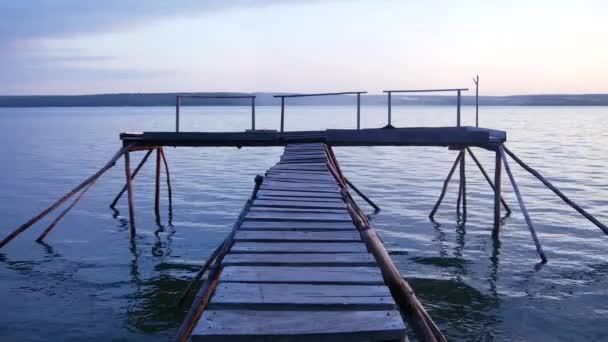 Wooden pier on the lake shore. Twilight. Peace and tranquility. — Stock Video