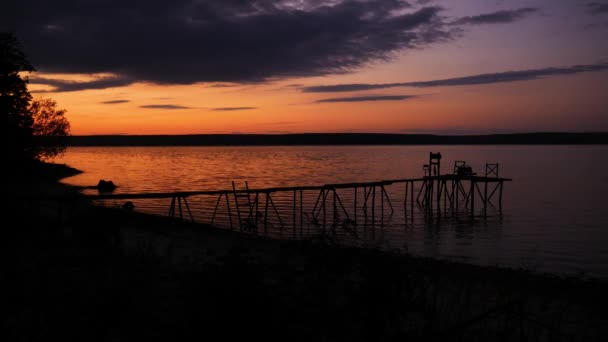 Perspektywny widok na drewniane molo nad stawem o zachodzie słońca z doskonale spekulacyjnym odbiciem — Wideo stockowe