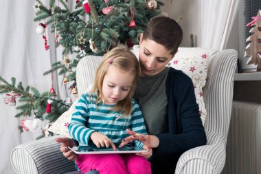 Anne ve kızı kullanarak tablet Pc Noel ağacının yanında