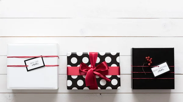 Mnoho elegantní a krásně zabalené černé, červené a bílé vánoční dárky — Stock fotografie