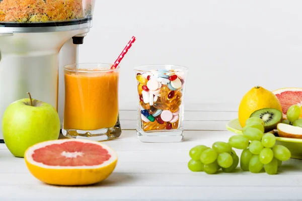 Estilo de vida saudável e conceito de dieta. Suco de frutas, pílulas e suplementos vitamínicos, conceito de escolha no fundo branco — Fotografia de Stock