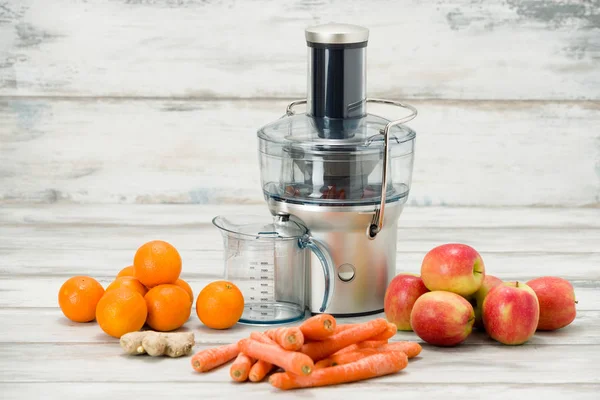 Exprimidor eléctrico moderno y varias frutas en el mostrador de la cocina, concepto de estilo de vida saludable — Foto de Stock