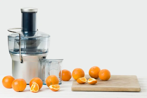 Modern electric juicer and fresh oranges, white background with copy space — Stock Photo, Image