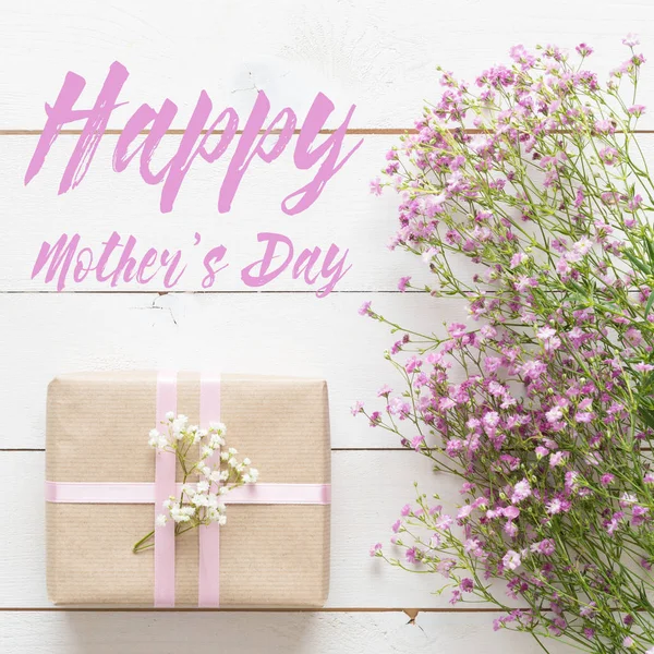 Muttertagshintergrund, weißer Holztisch mit rosa Blumen und einem Geschenk — Stockfoto