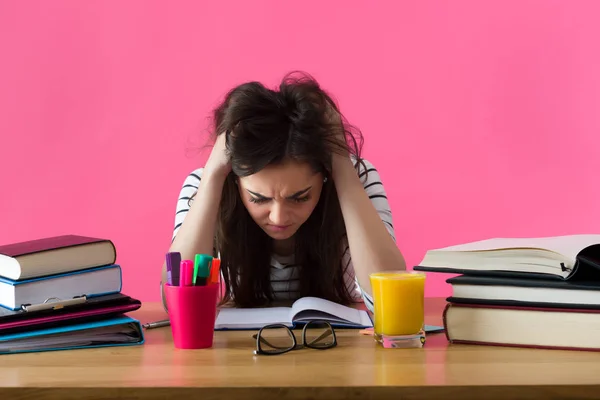 Estudiante frustrada. Joven estudiante con expresión desesperada sentada en su escritorio . — Foto de Stock