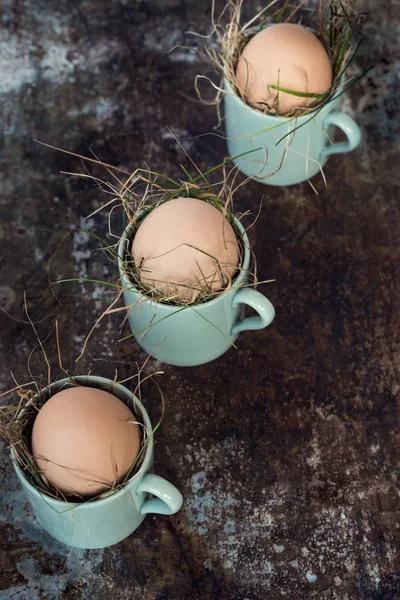 Uncolored natural easter eggs in green espresso cups, happy easter concept, retro easter background — Stock Photo, Image