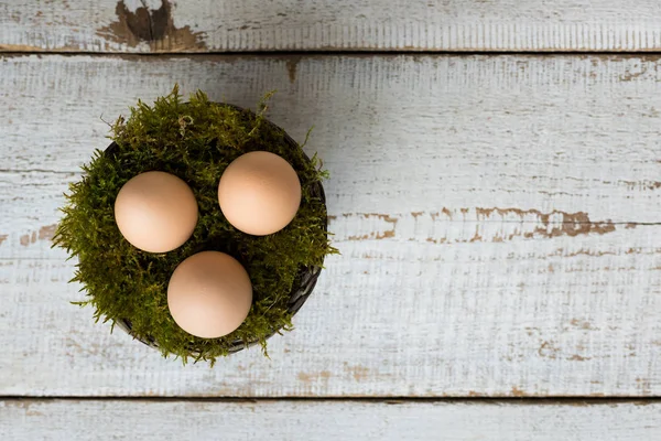 Trzy jaja wielkanocne w moss kosz, happy easter koncepcja, retro tło Wielkanoc — Zdjęcie stockowe