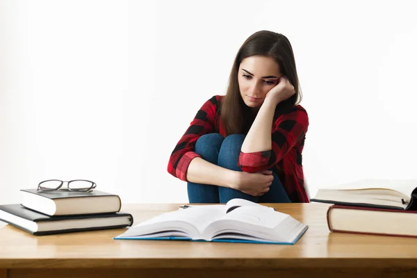 Estudiante frustrada. Joven estudiante con expresión desesperada sentada en su escritorio . — Foto de Stock
