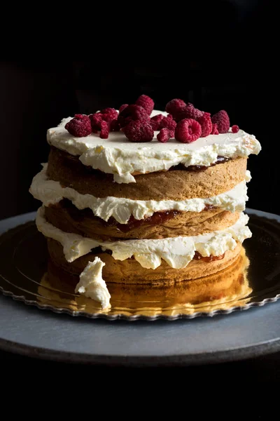 Delicious layered sponge cake with icing cream and raspberries — Stock Photo, Image