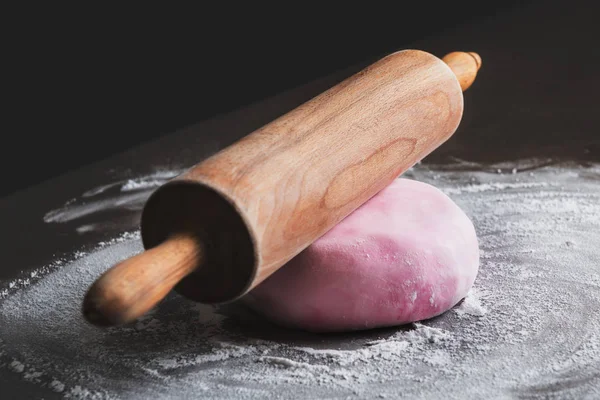 Rolling pin and pink sugar paste on kitchen counter — Stock Photo, Image