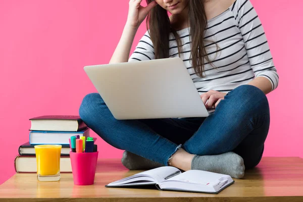 Attractive caucasian girl studying for her exams at home, student sitting on her desk with laptop in her lap — Stock Photo, Image