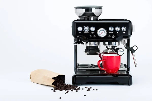 Cafetière manuelle noire isolée avec broyeur et tasse à café rouge et sac de grains de café fraîchement torréfiés sur fond blanc, vue de face — Photo