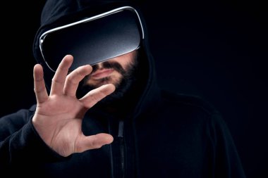 Sanal gerçeklik giyen genç hipster sakallı adam gözlükler. Siyah arka plan stüdyo Vr kavramı