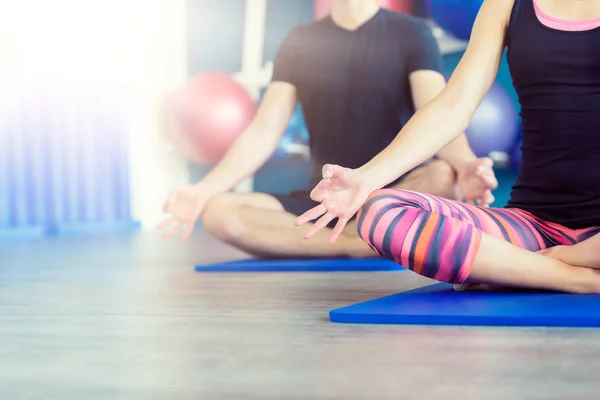 Frumos cuplu face yoga într-un studio. Tineri în clasa de yoga în poziție de lotus. Conceptul yoga . — Fotografie, imagine de stoc