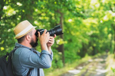 Erkek fotoğrafçı ile sırt çantası ve fotoğraf makinesi fotoğraf çekme. Yaşam tarzı Hobi kavramı macera aktif tatiller açık seyahat