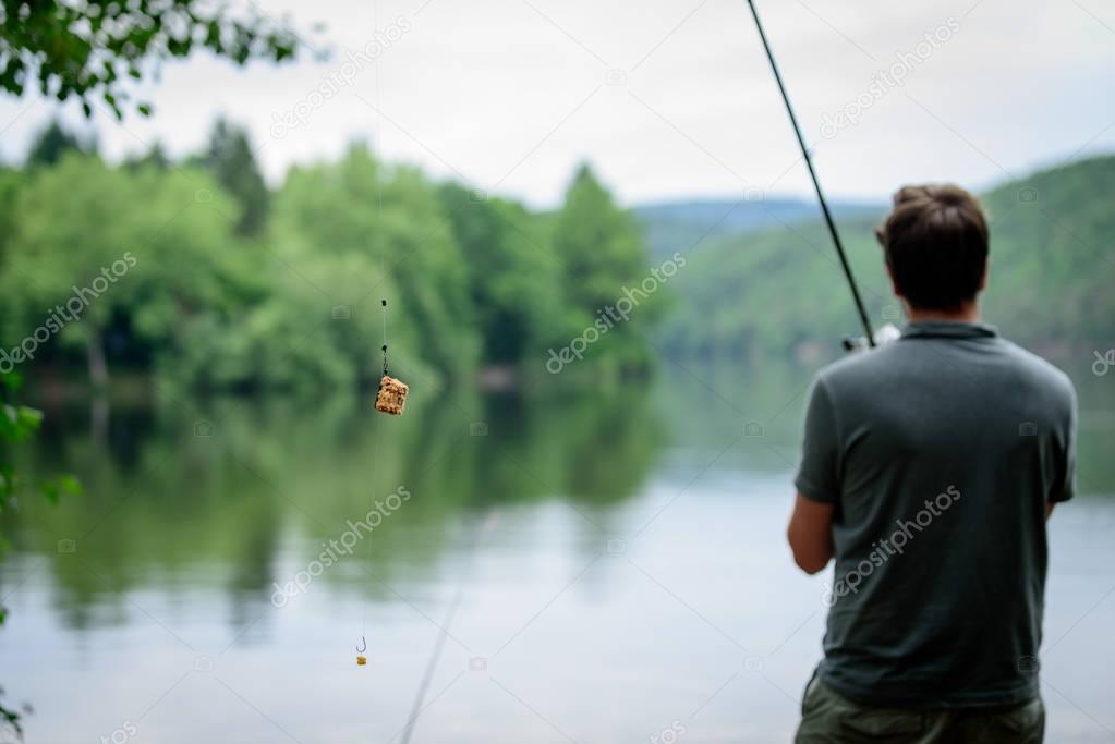 Fisherman standing on the banks of Vltava, fishing getaway concept