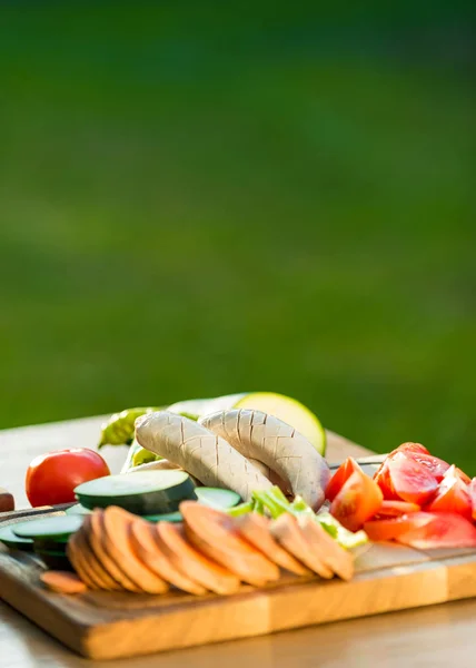 Kawałki świeżych warzyw i kiełbasy na pokładzie cięcia, bbq letnich ogród jedzenie koncepcja — Zdjęcie stockowe