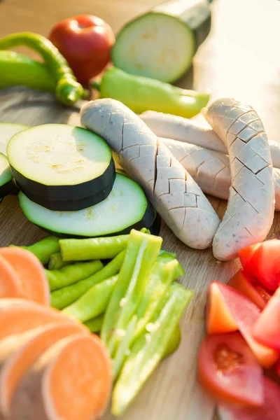 Freshly cut vegetables and sausages on a cutting board, bbq summer garden food concept — Stock Photo, Image