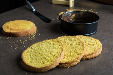 Taze pişmiş kek formu ve spatula mutfak tezgahı üzerinde pişirme kek ile dört kat kesmek