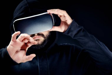 Genç hipster Kapşonlu üst, sanal gerçeklik giyen gözlük siyah adam sakallı. Siyah arka plan stüdyo Vr kavramı