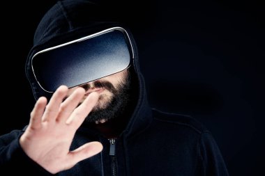 Genç hipster Kapşonlu üst, sanal gerçeklik giyen gözlük siyah adam sakallı. Siyah arka plan stüdyo Vr kavramı
