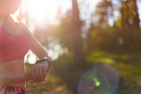 Aantrekkelijke vrouwelijke atleet met behulp van fitness app op haar slimme horloge training prestaties controleren. — Stockfoto