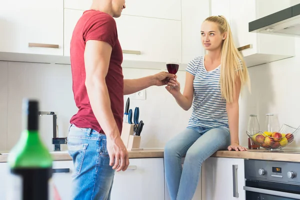 Çekici genç beyaz adam mutfak tezgahına, kırmızı şarap oturan arkadaşı sunan