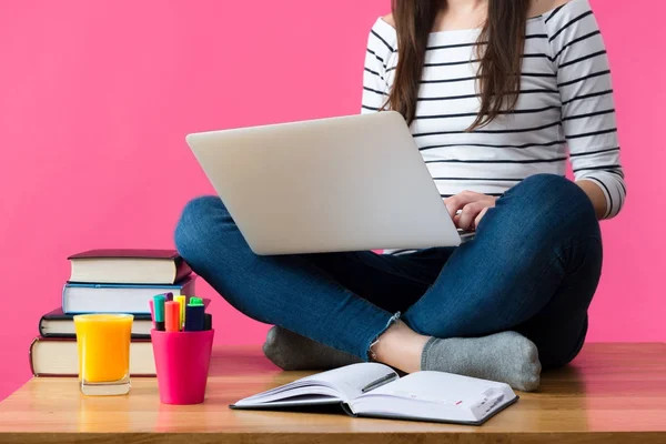 Mujer estudiando para sus exámenes en casa. Estudiante sentada en su escritorio con portátil en su regazo, escribiendo notas e investigando — Foto de Stock