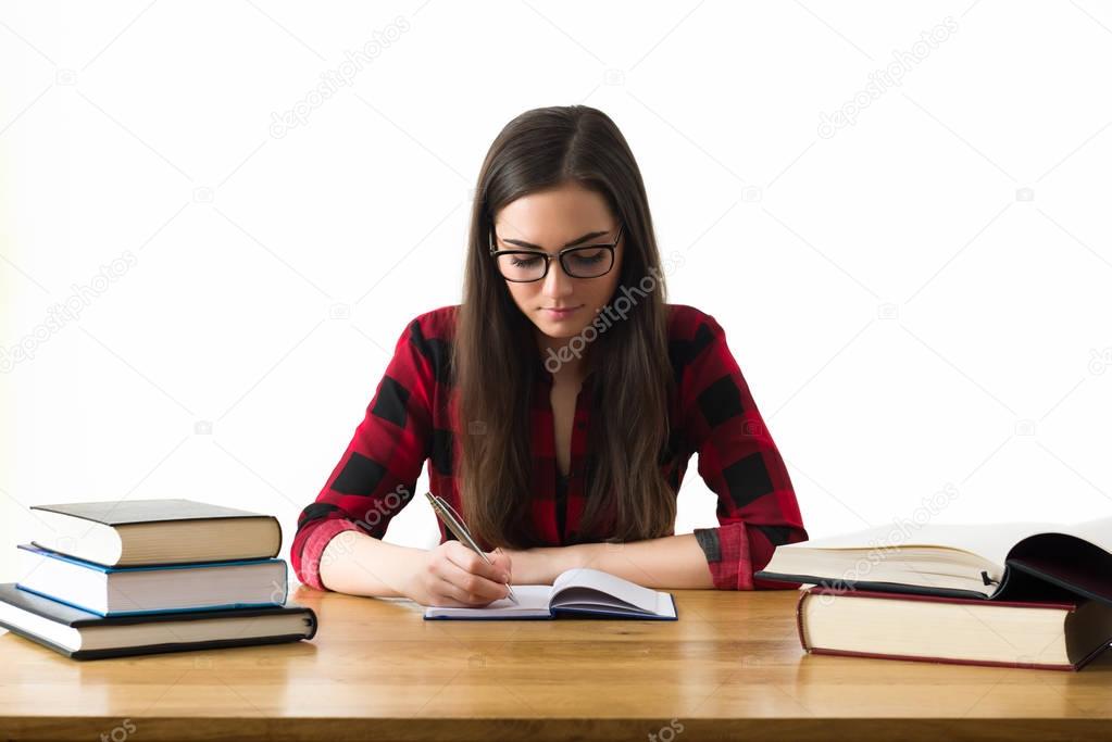 Attractive caucasian girl studying for her exams at home, education concept on white background