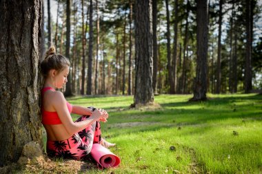 Yoga egzersiz yaptıktan sonra bir mola ve akıllı saatini kontrol genç çekici kadın. Spor, fitness, egzersiz kavramı