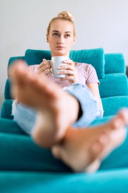 TV izlerken, kahve zevk güzel genç kadın evde kanepede rahatlatıcı