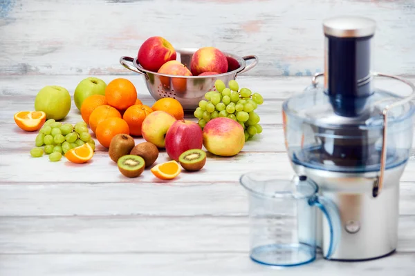 Moderní elektrické odšťavňovače a různé ovoce na kuchyňské lince, detoxikační koncept zdravého životního stylu — Stock fotografie