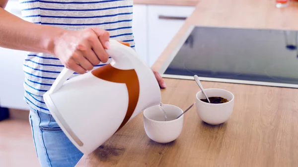 Donna irriconoscibile che prepara caffe 'turco. Versare acqua in una tazza . — Foto Stock