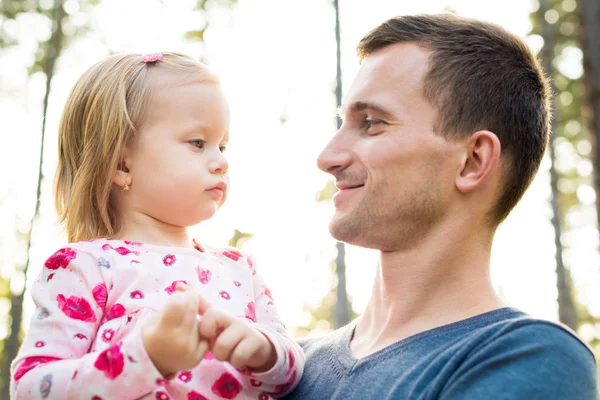 Gülümseyen ve ona bakmak genç Baba holding şirin bebek kız kız kolunu içinde — Stok fotoğraf