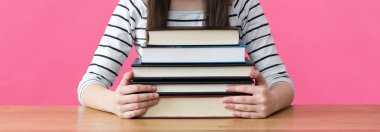 Ders kitapları ile masasında oturan kız öğrenci