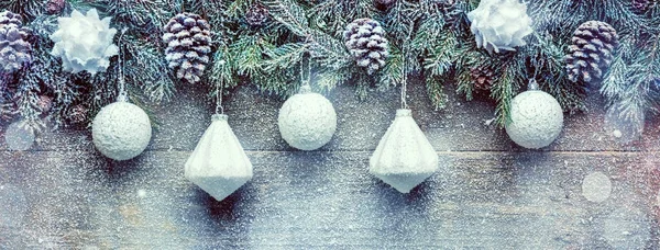 Karlı Noel arka plan, köknar ağacı dalları ile çam kozalakları ve Xmas Baubles ahşap arka plan, kopya alanı ile festival afiş üzerinde — Stok fotoğraf