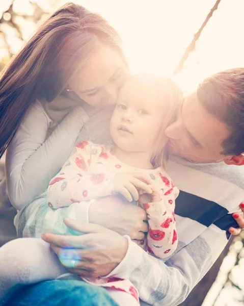 Joven familia de tres personas divirtiéndose en un parque disfrutando de su tiempo juntos. Personas reales, familia real, concepto de autenticidad — Foto de Stock