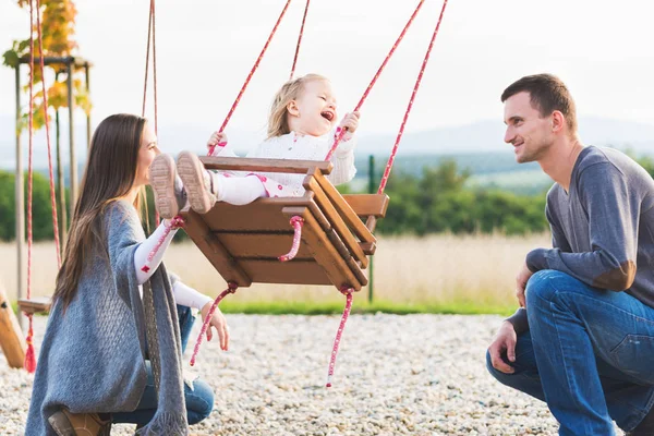 Familia Con Niñita Balanceándose Patio Recreo Infancia Familia Feliz Concepto — Foto de Stock