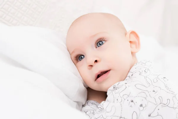 Förtjusande Baby Pojke Med Blå Ögon Liggande Säng Tittar Bort — Stockfoto